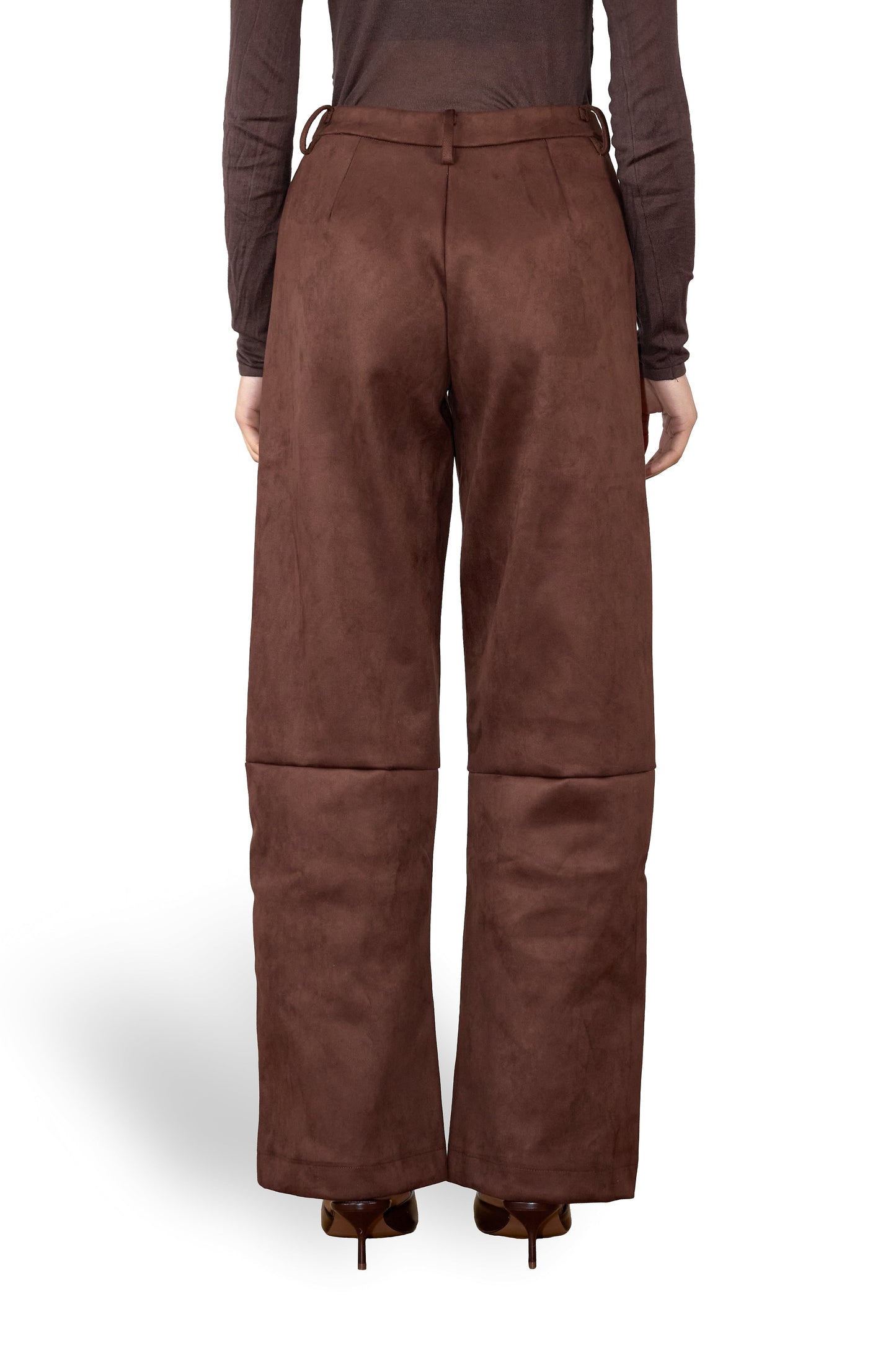 Brown suede pants worn by a person on a white background
