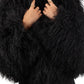 Person wearing a Black Mongolian fur coat  against a white background