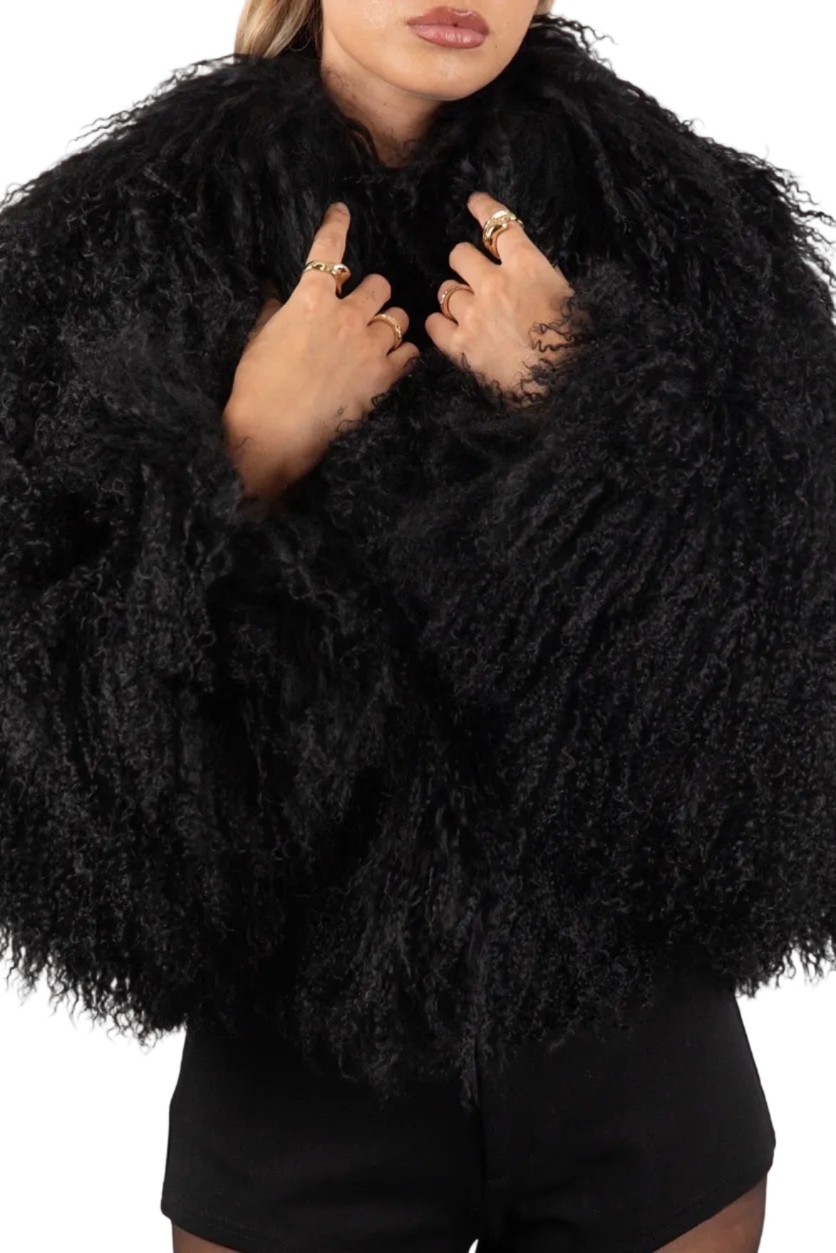 Person wearing a Black Mongolian fur coat  against a white background