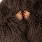 Close-up of a person wearing a brown Mongolian fur coat  with a neutral background