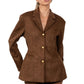 Woman wearing a brown suede jacket and shorts on a white background