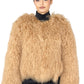 Person wearing a Beige Mongolian fur coat on a white background