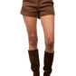 Person wearing brown high-waisted shorts and knee-high boots on a plain background