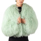 Person wearing a light gree mongolian fur jacket on a white background
