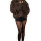 Person wearing a brown shaggy coat against a white background