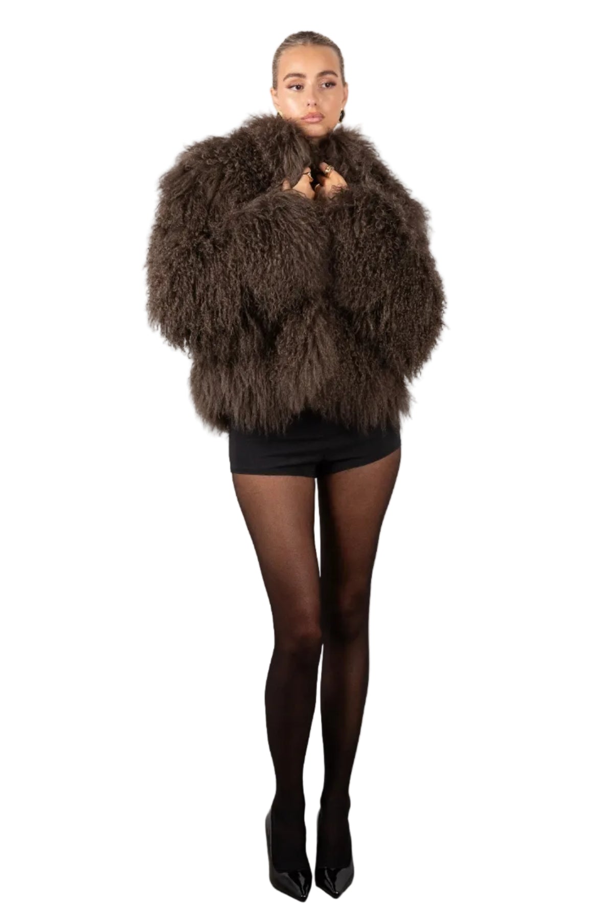 Person wearing a brown shaggy coat against a white background