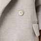 Close-up of a gray blazer with buttons on a plain background